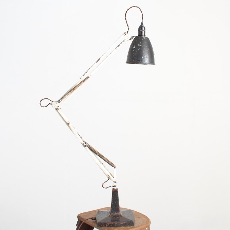 A turned table lamp with a linen shade, framed by white sheers